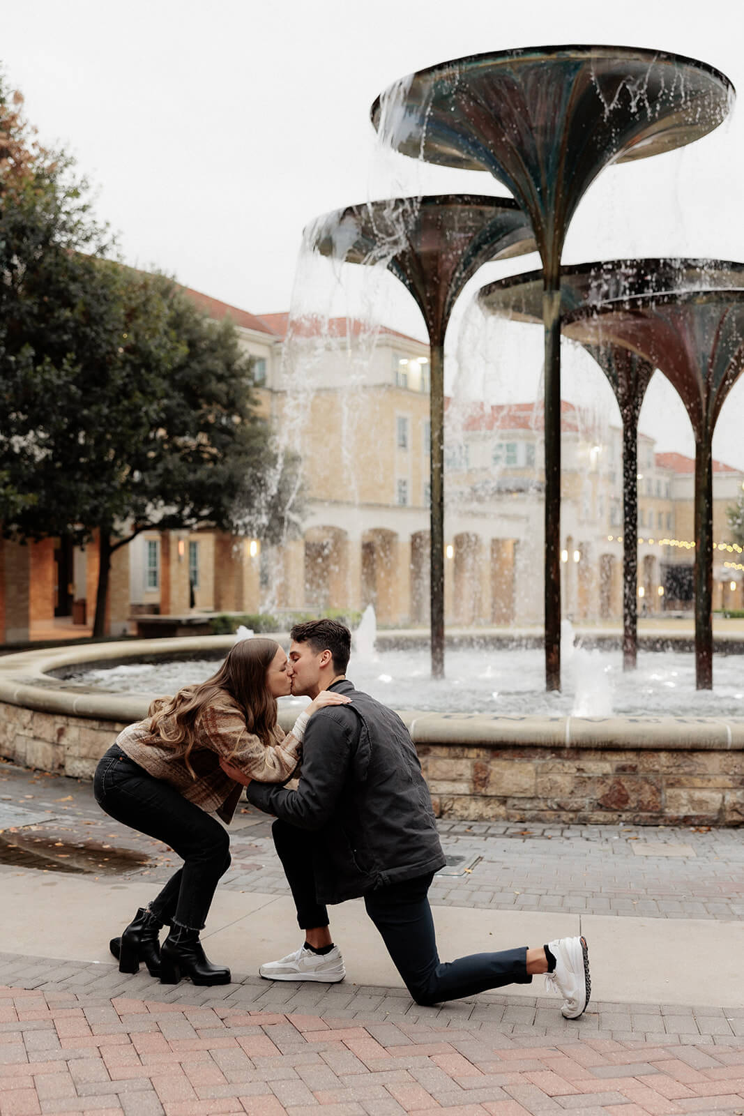 couple kissing during proposal in front of frog fountain | Texas Christian University Proposal