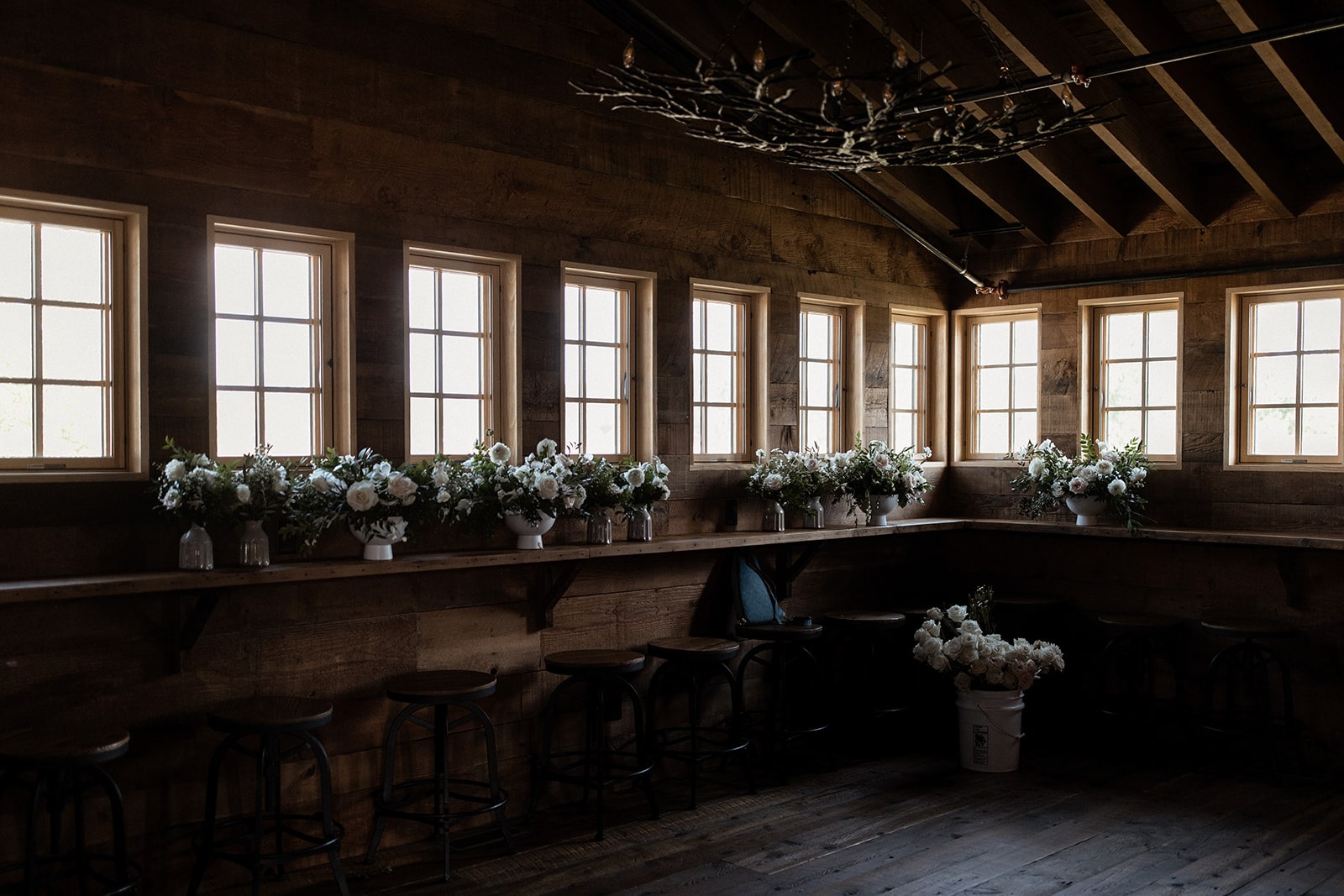 Wedding flowers lined up on a barn shelf during Bozeman wedding at Firelight Farm