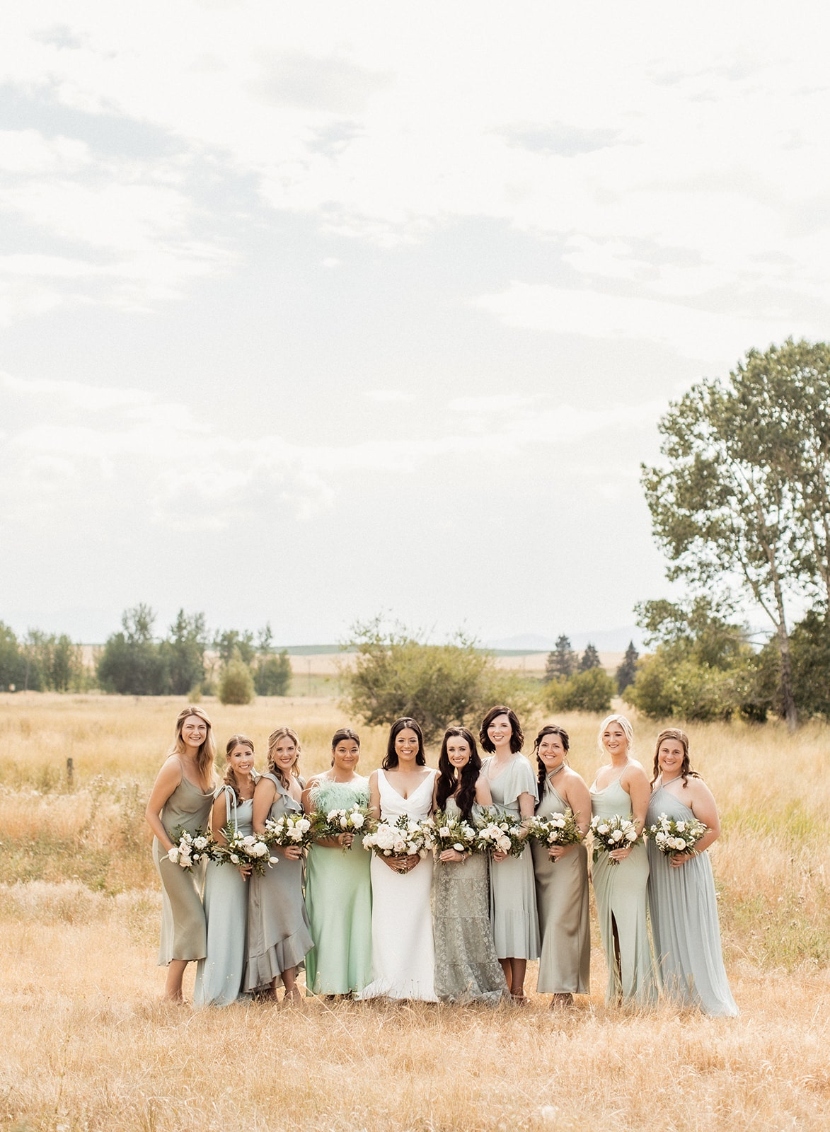 Bride poses with wedding party in a Montana field