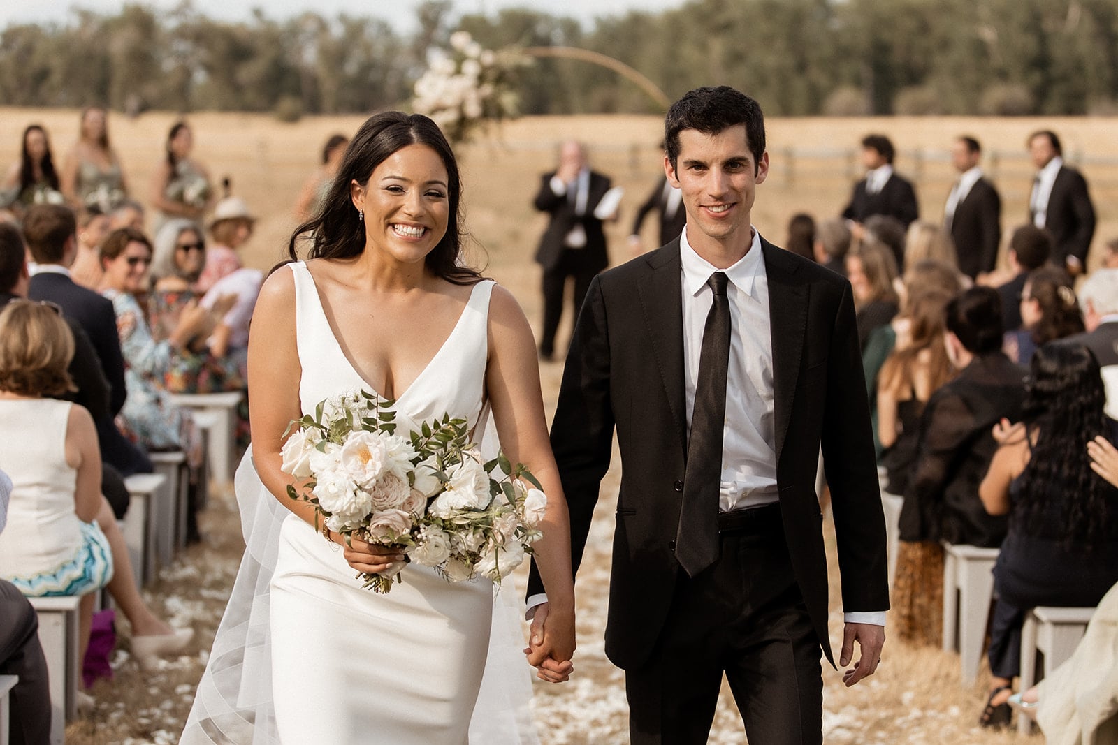 Bride and groom hold hands as they exit their Montana wedding in Bozeman