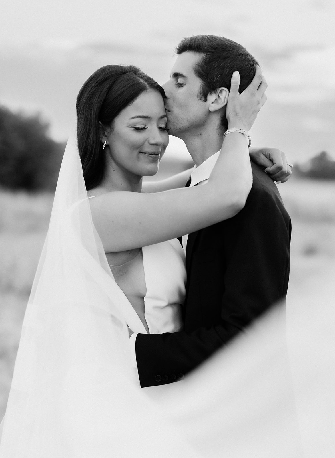 Bride and groom kiss in the field during their Bozeman wedding at Firelight Farm