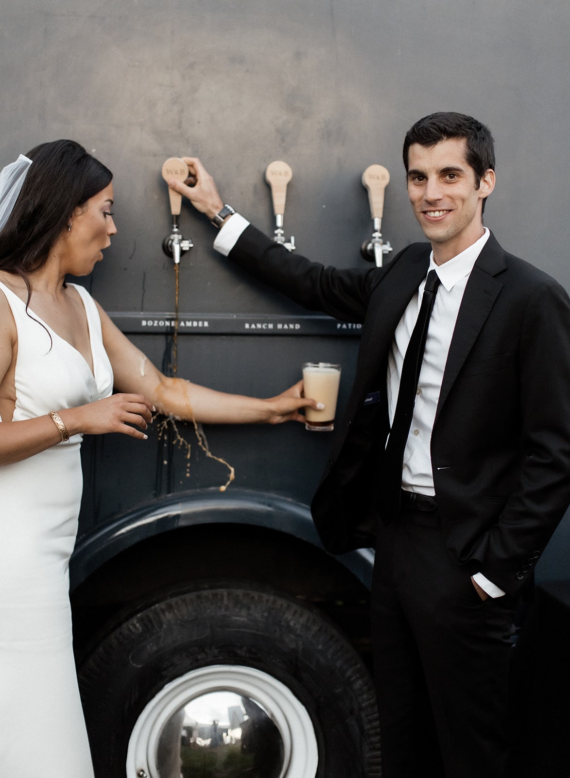 Groom pours beer on tap from a beer truck at Firelight Farm wedding reception