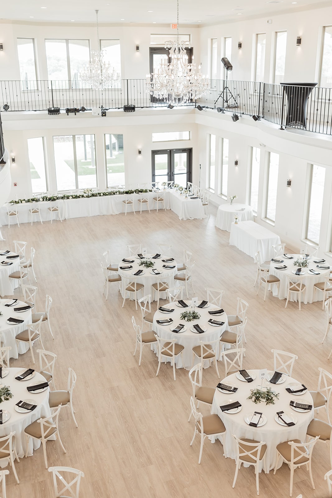 Round white wedding reception tables with black place settings 