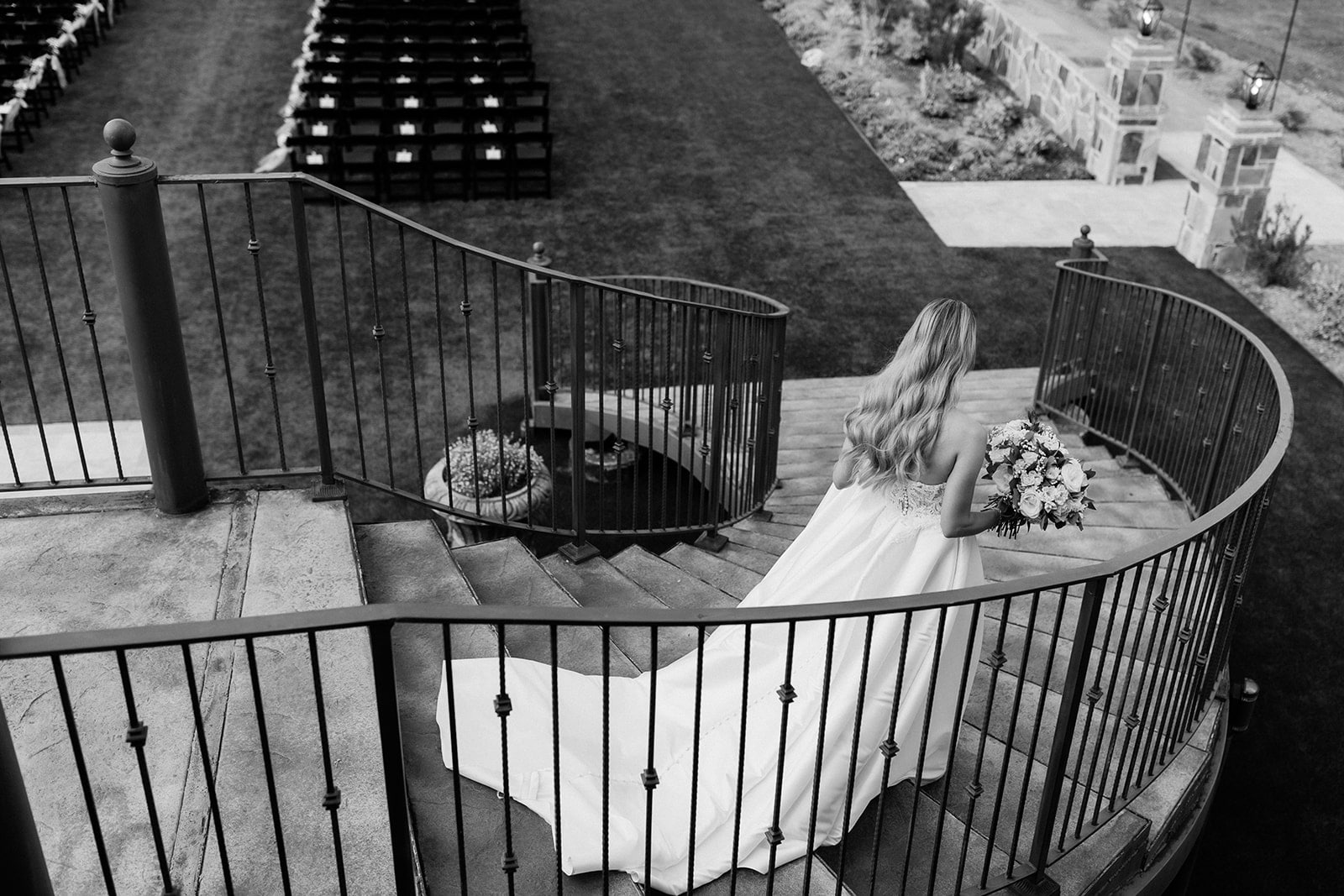 Bride walks down a black iron staircase at Italy-themed wedding venue in Texas