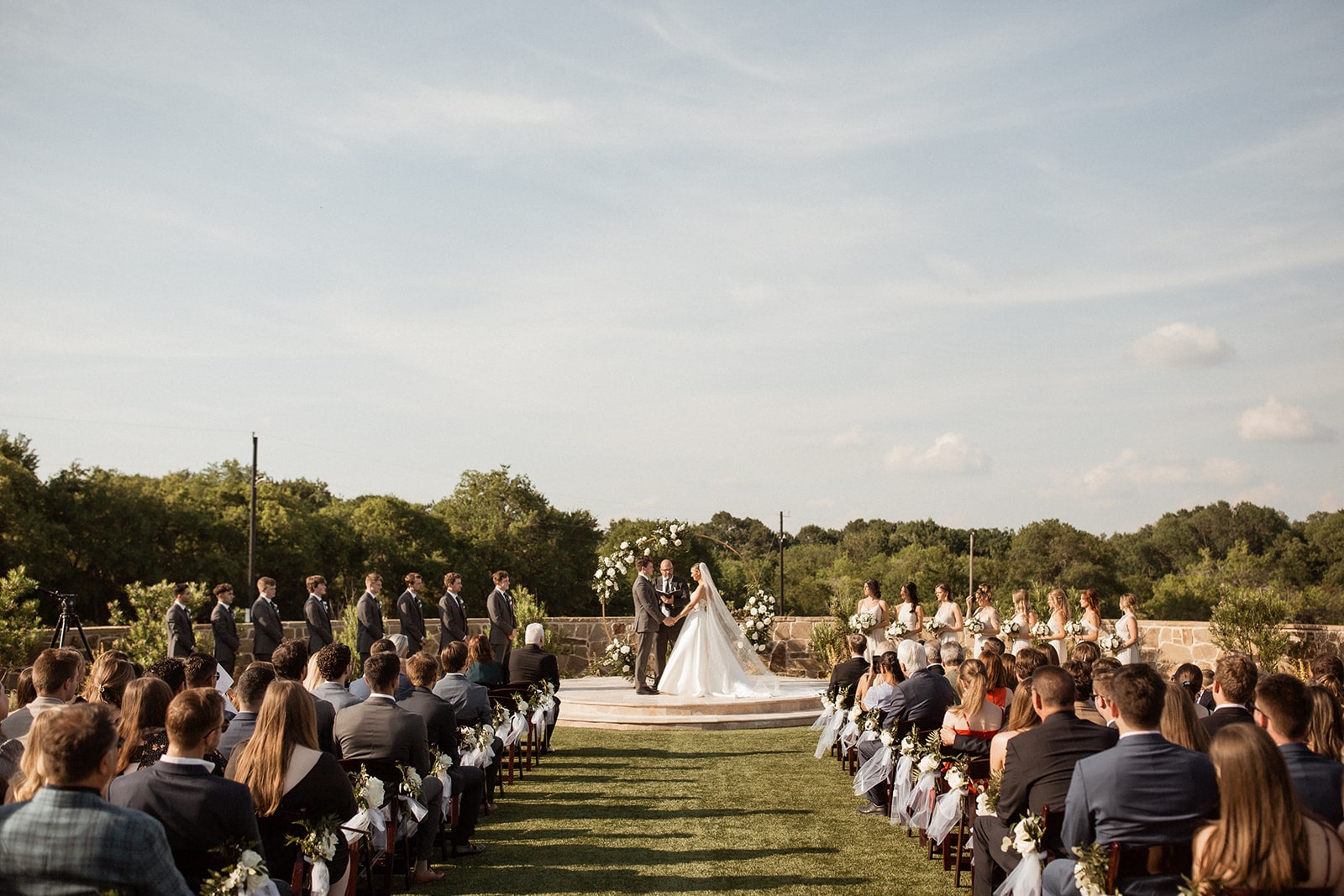 Bride and groom hold hands at the altar during their north Texas wedding in Texas