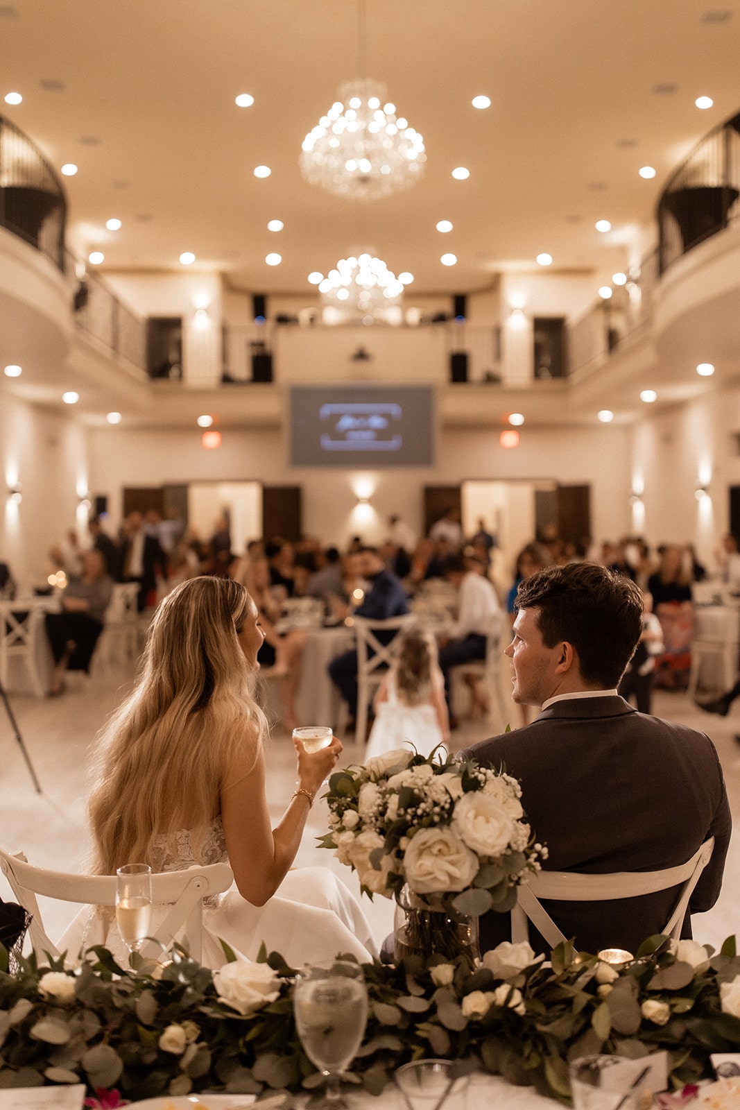 Bride and groom sit and sip cocktails during their wedding reception at D'vine Grace Vineyard