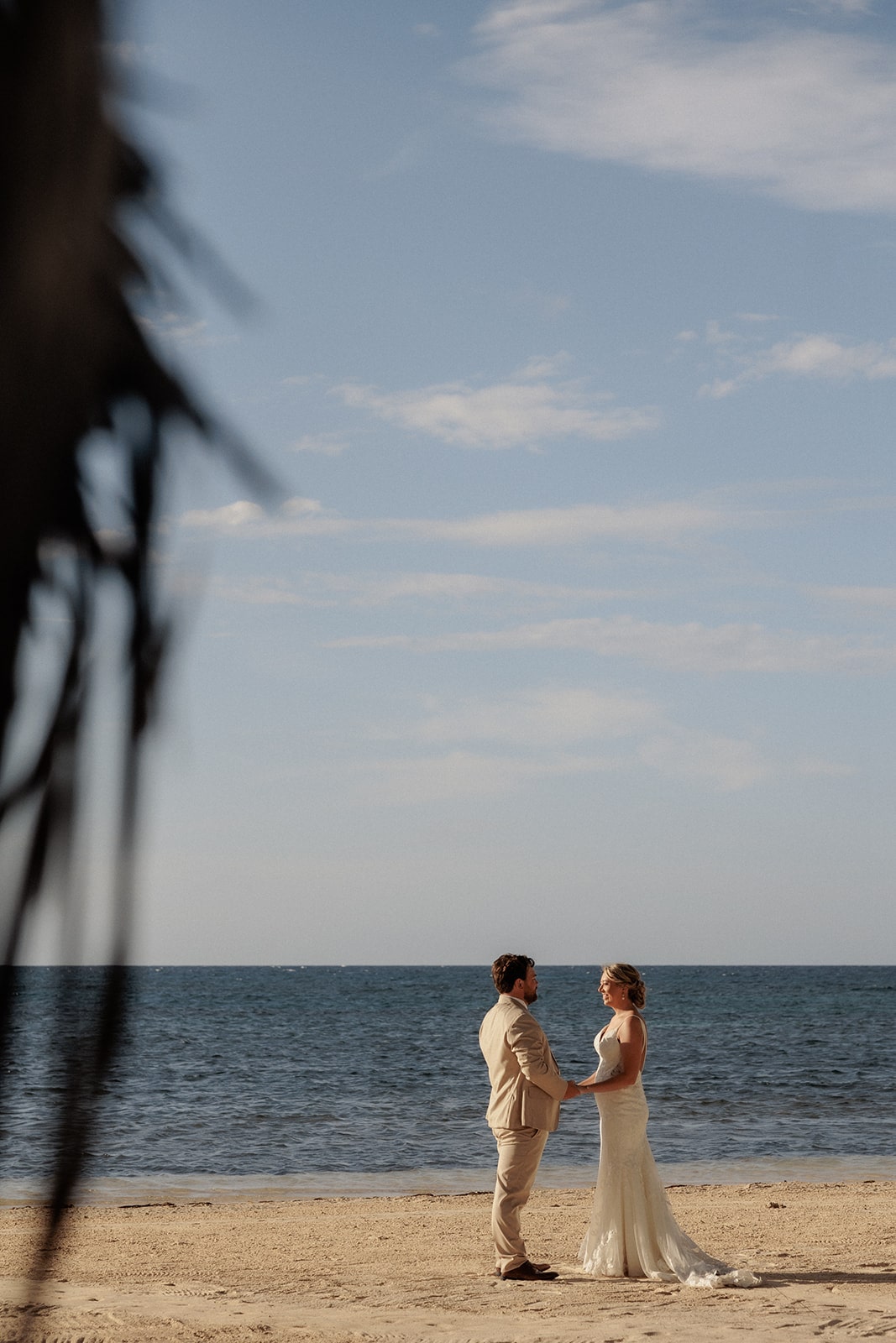 Bride and groom hold hands on the beach after their wedding ceremony in Jamaica