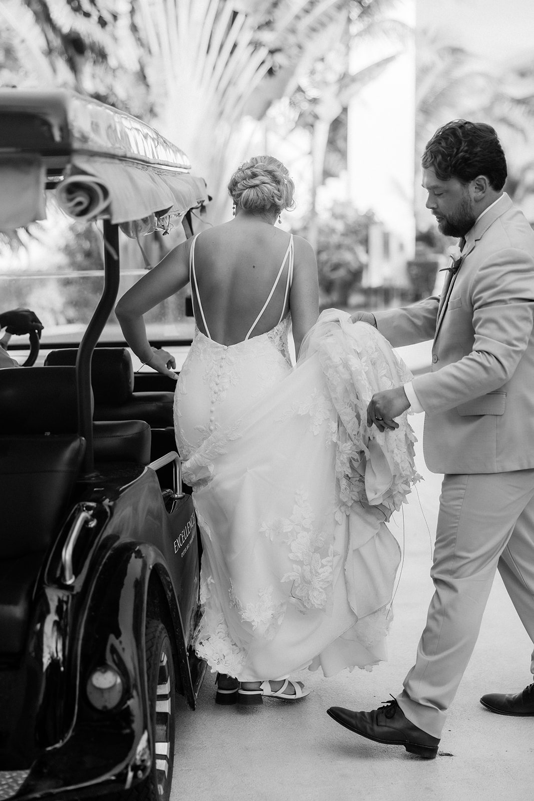 Groom helps bride into a golf cart after their beach wedding ceremony in Jamaica