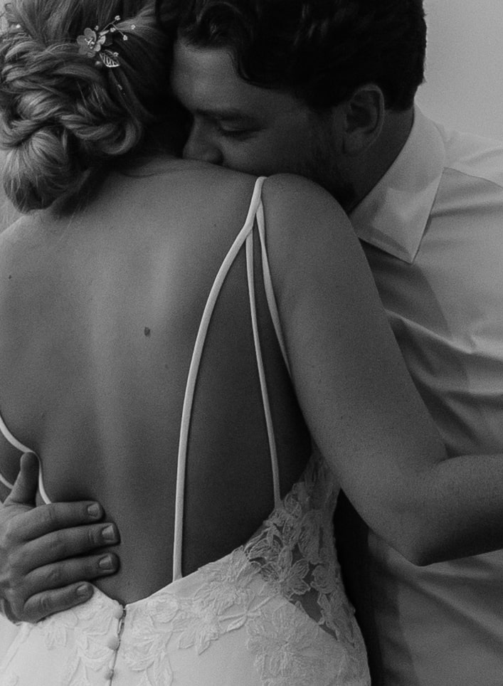 Groom hugs bride close during their wedding first dance at Excellence Oyster Bay resort 