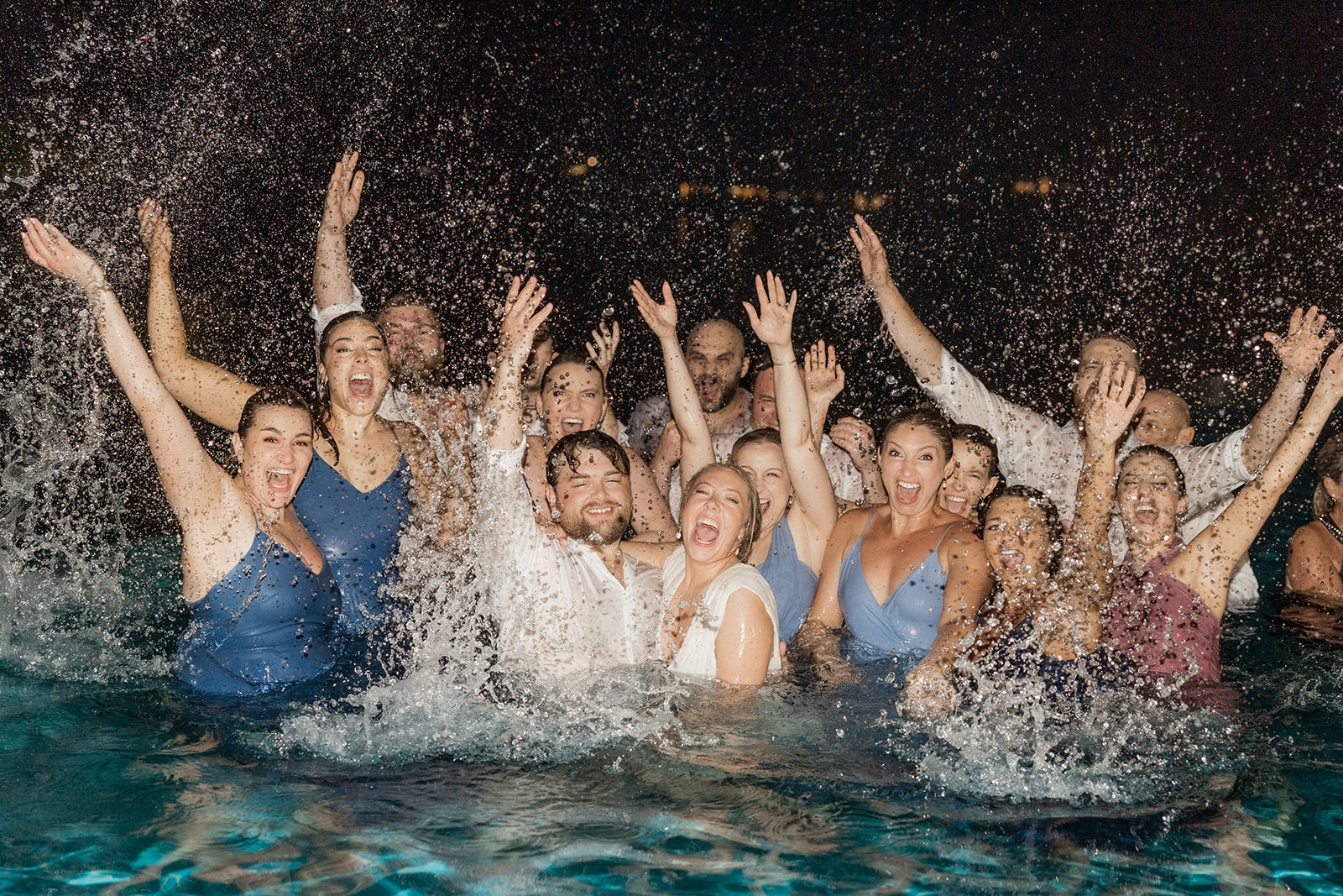 Wedding party splashes in the pool after the Montego Bay Jamaica wedding reception