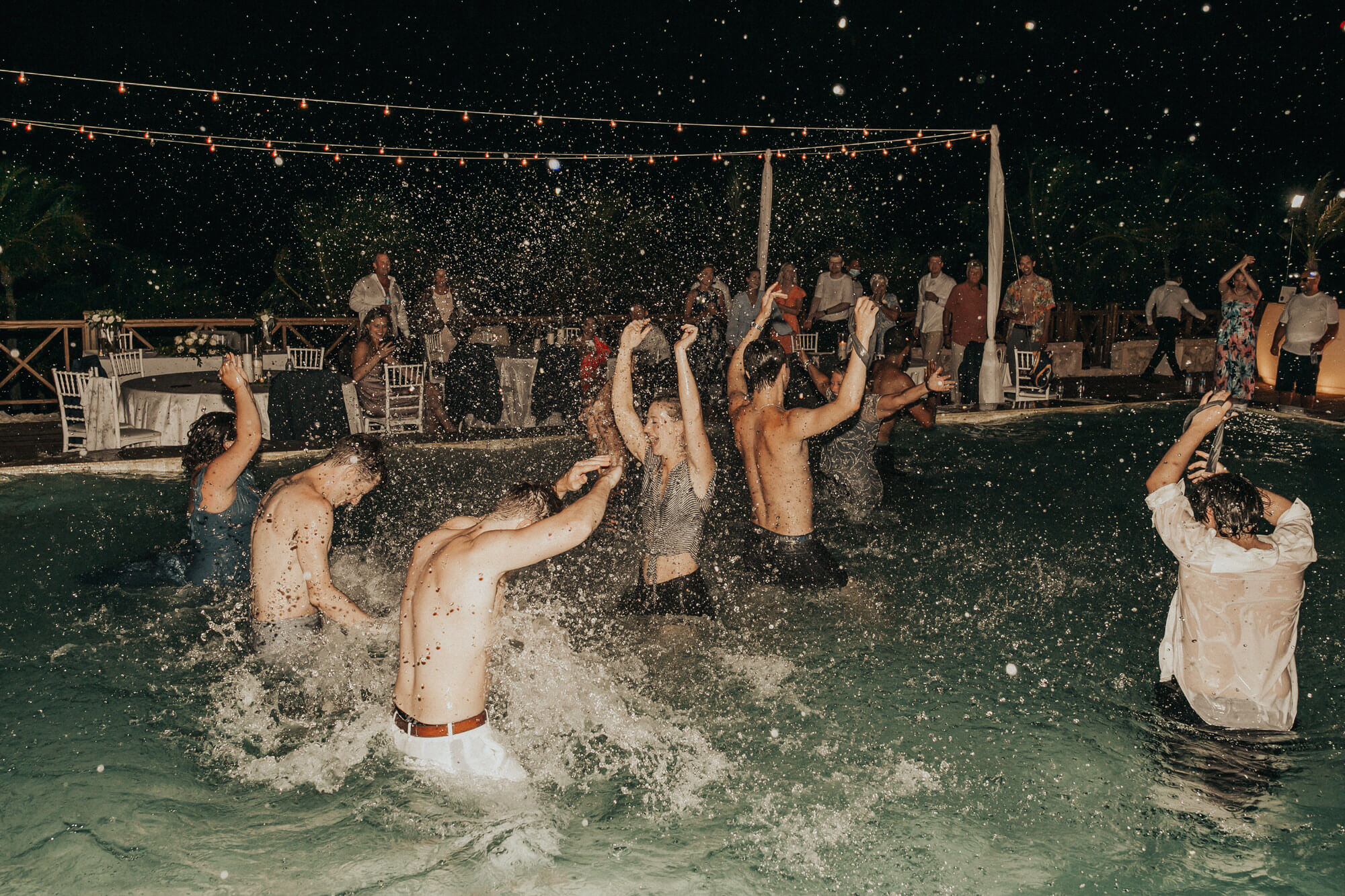 Guests splash in the pool at an Italy wedding reception