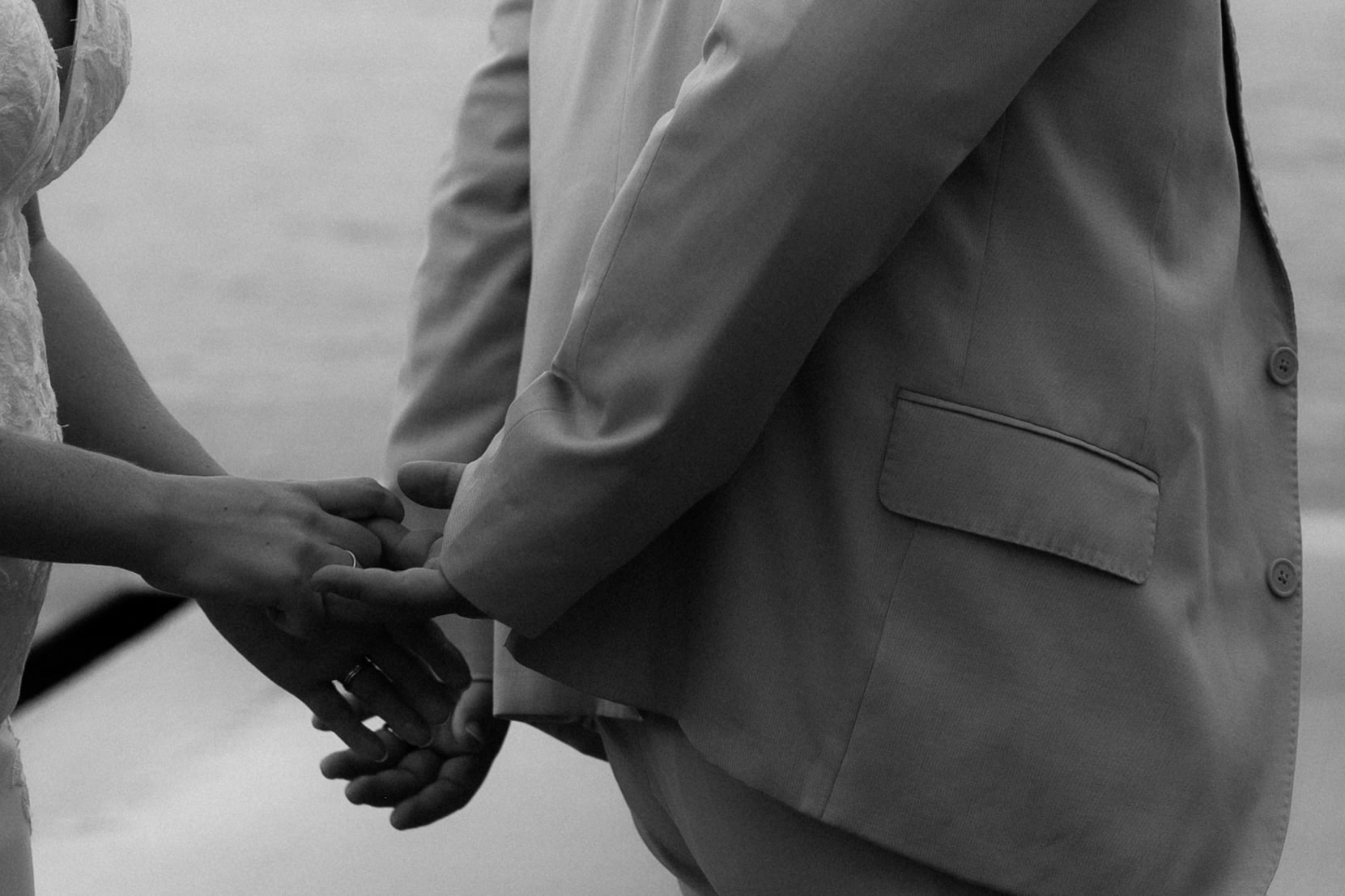 Bride and groom hold hands as they walk across the beach during their destination wedding photos