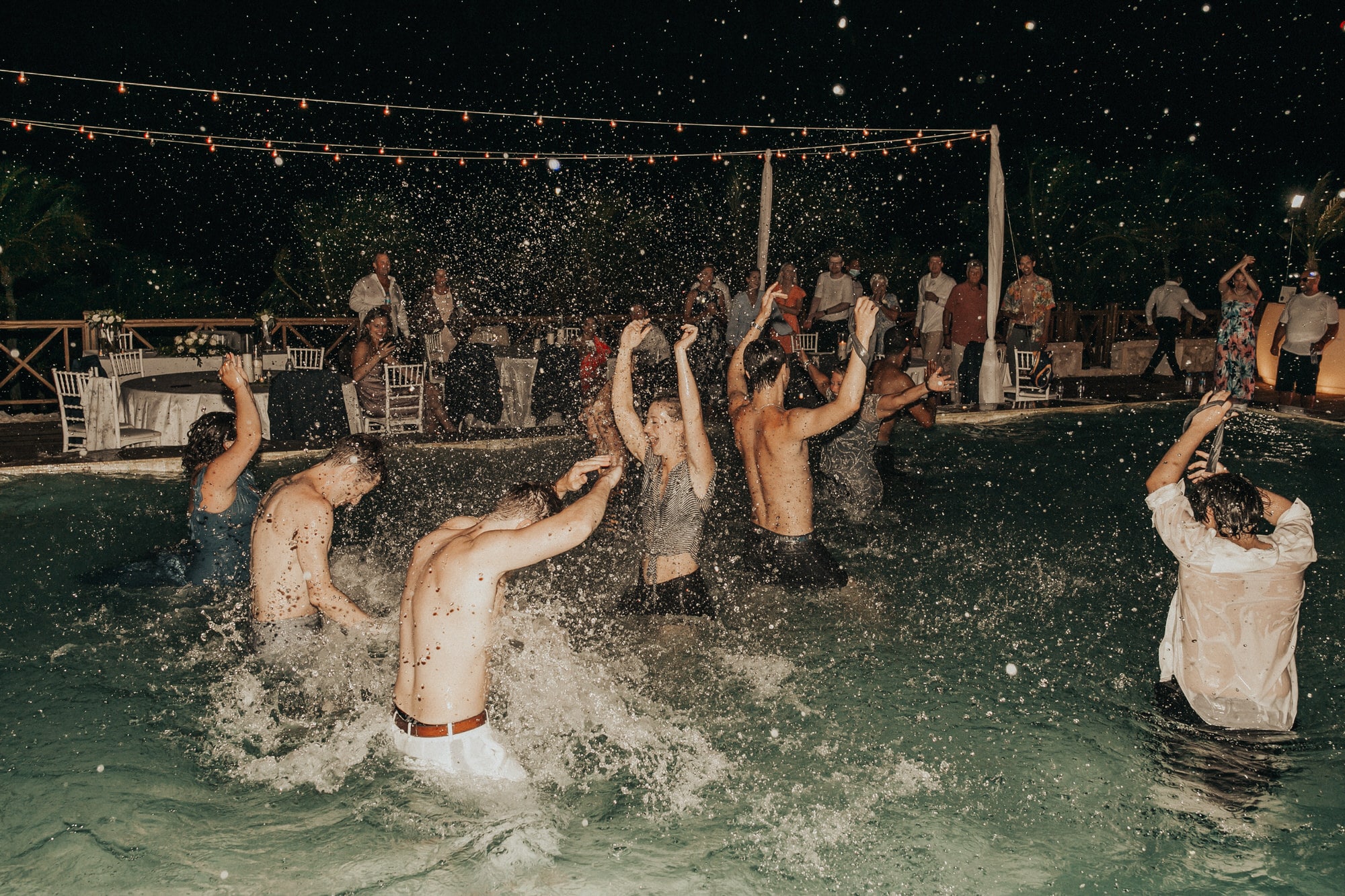 Guests splashing in a pool during a wedding reception in Puglia, Italy