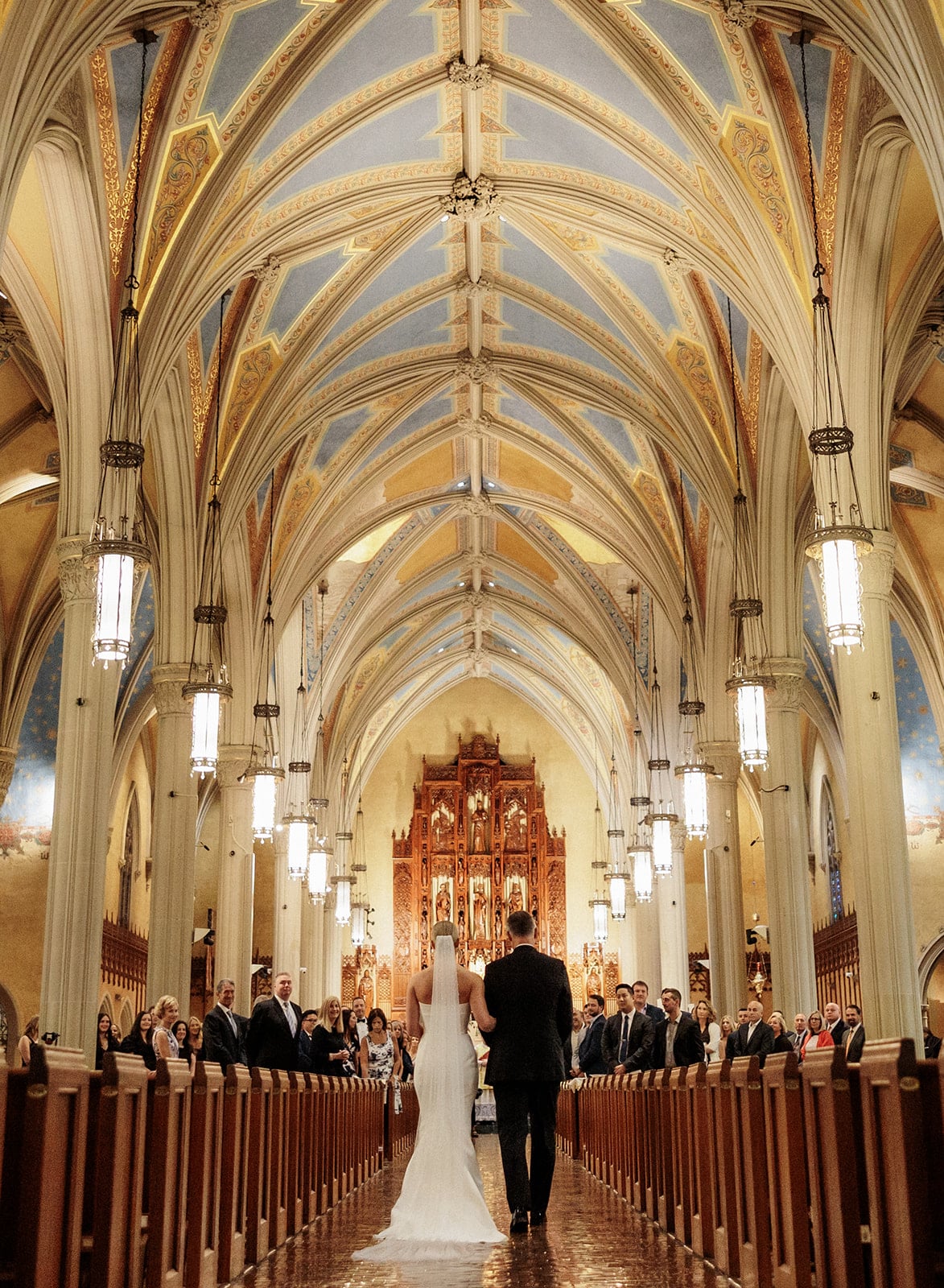 Bride and father walk down the aisle of a Catholic church in Cleveland, Ohio