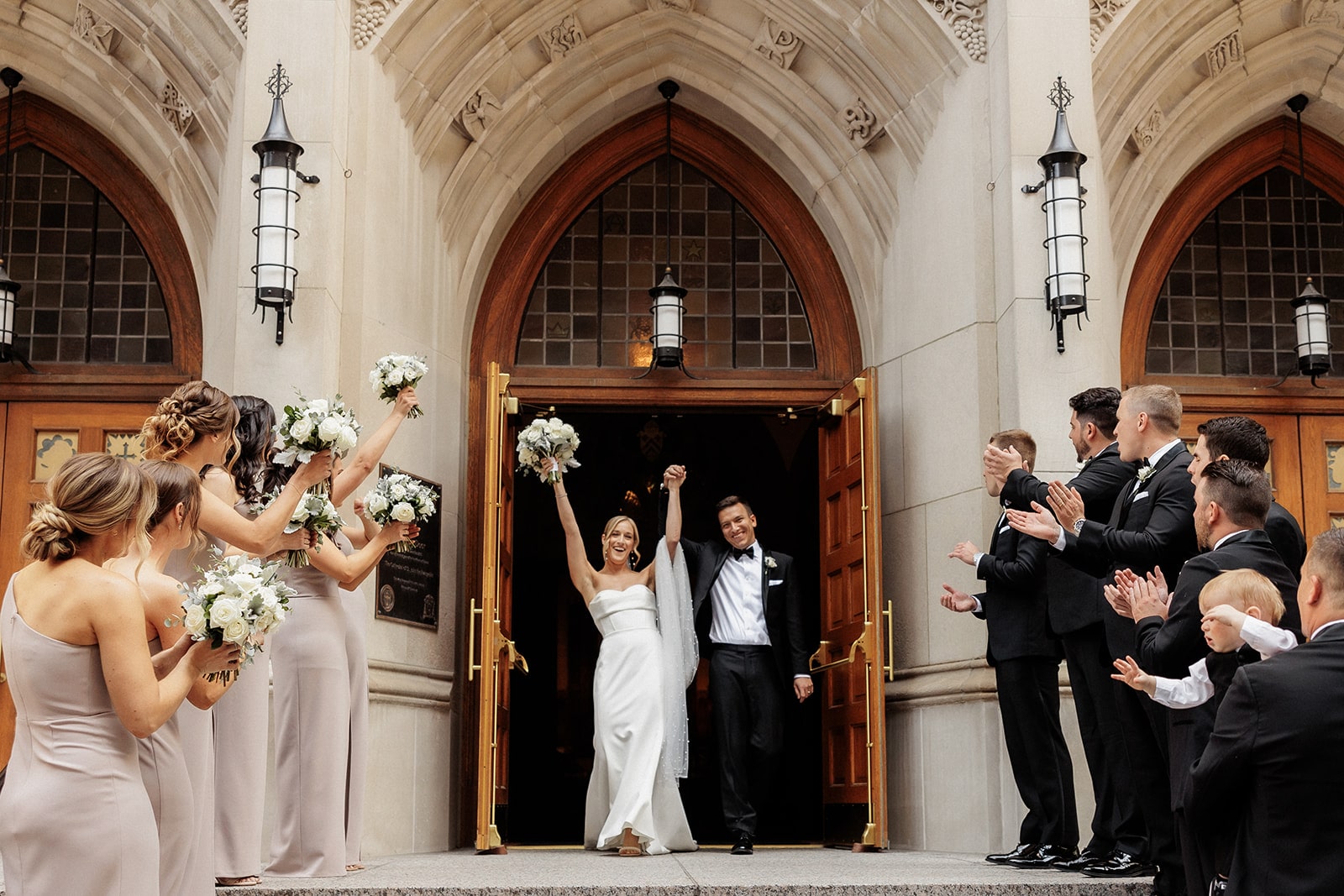 Bride and groom cheer as they exit the church after their Catholic wedding ceremony 