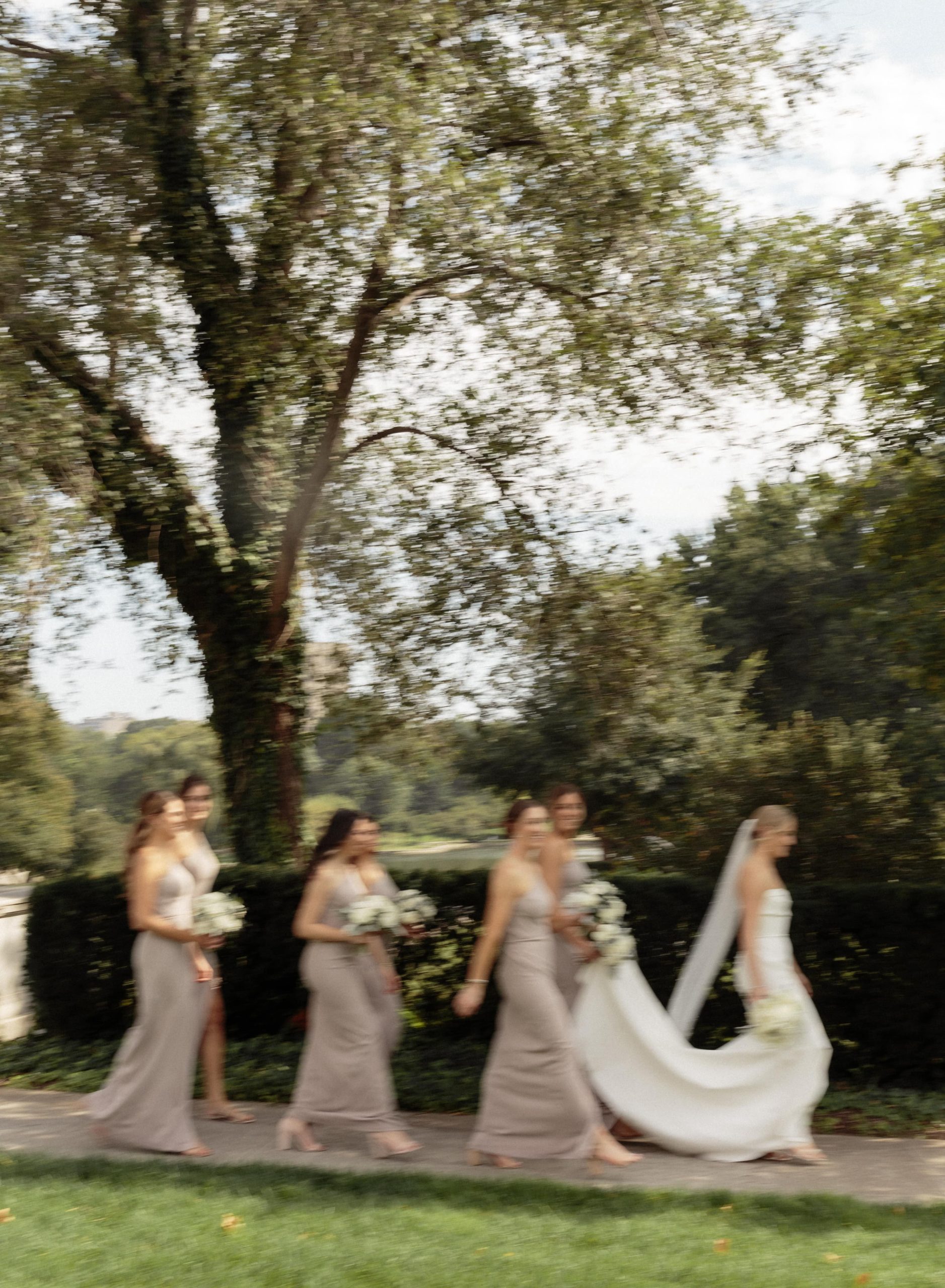 Wedding party walks bride down the sidewalk before museum wedding photos