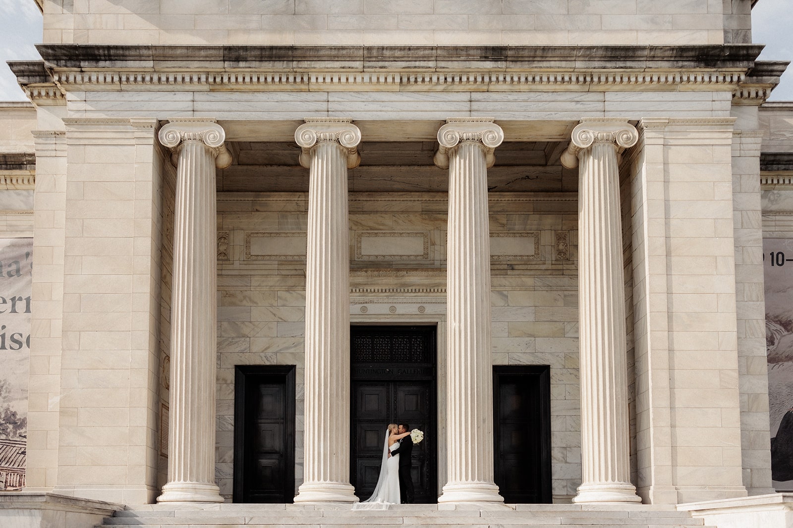 Bride and groom kiss on the steps of an art gallery in Ohio before their wedding reception 