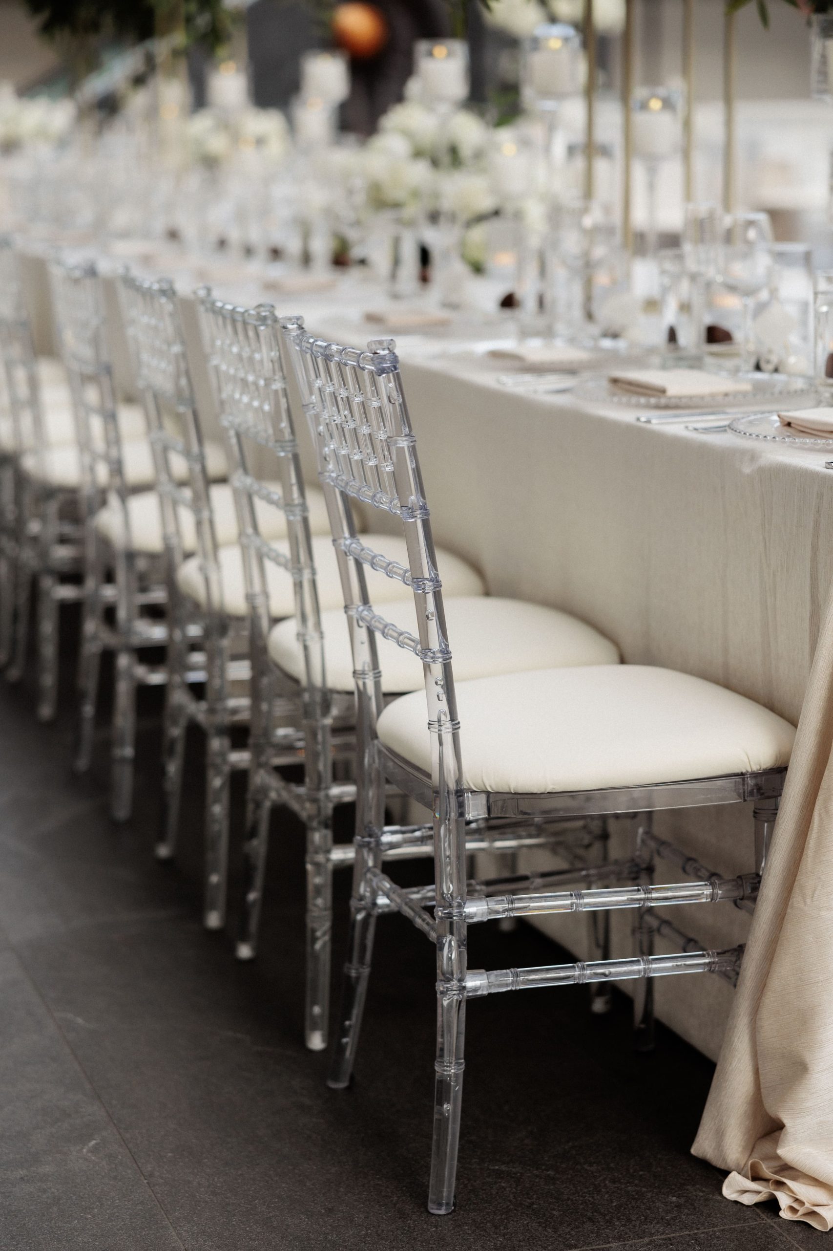 Acrylic chairs lined up at a museum wedding reception table