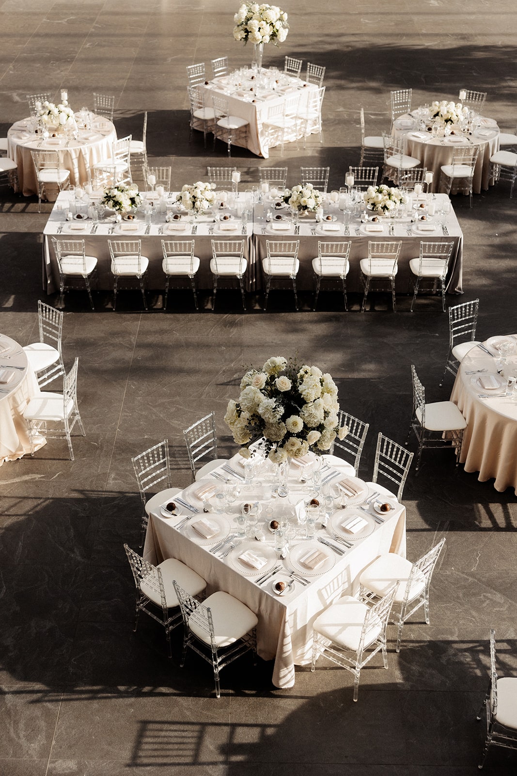 White art gallery wedding reception tables with tall white flower centerpieces