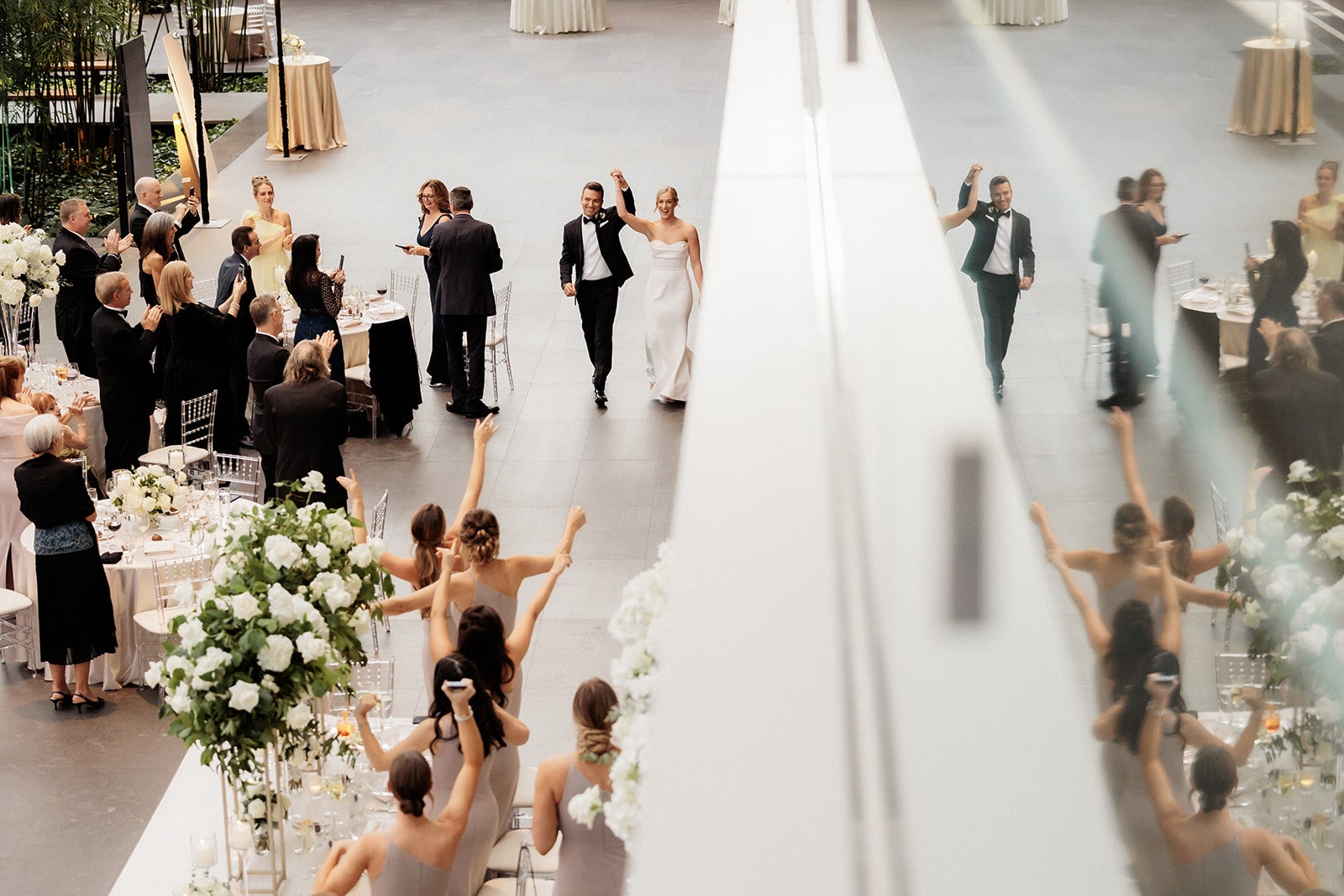 Guests clap and cheer as bride and groom enter their art gallery wedding reception in Ohio 