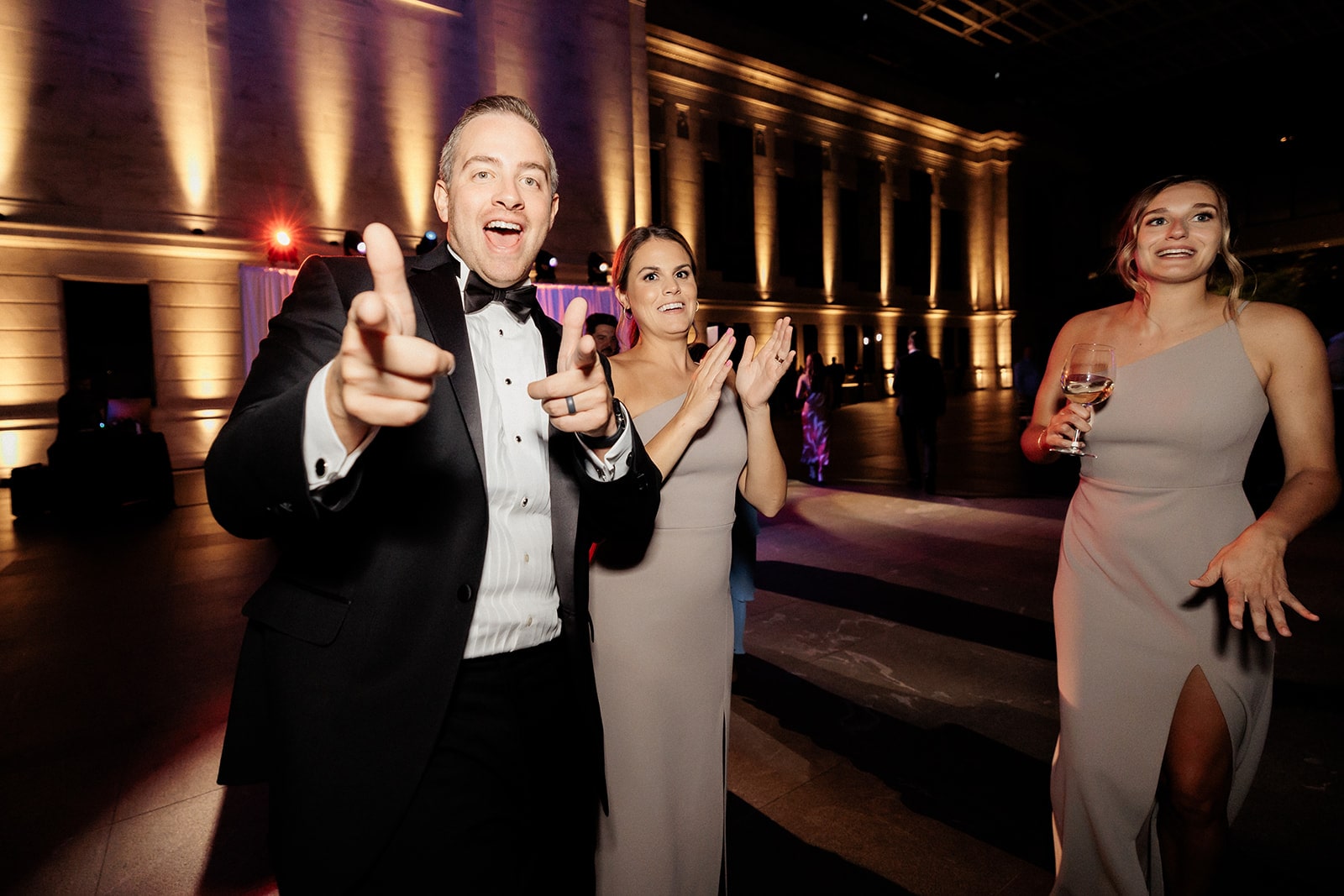 Guests clap and dance during an art gallery wedding reception dance