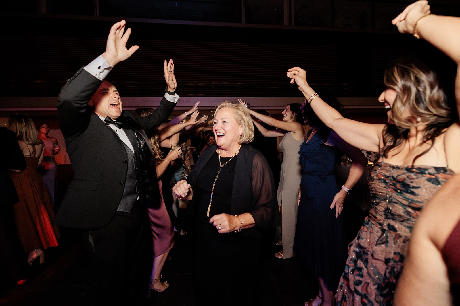 Guests cheer and dance during a museum wedding dance floor part