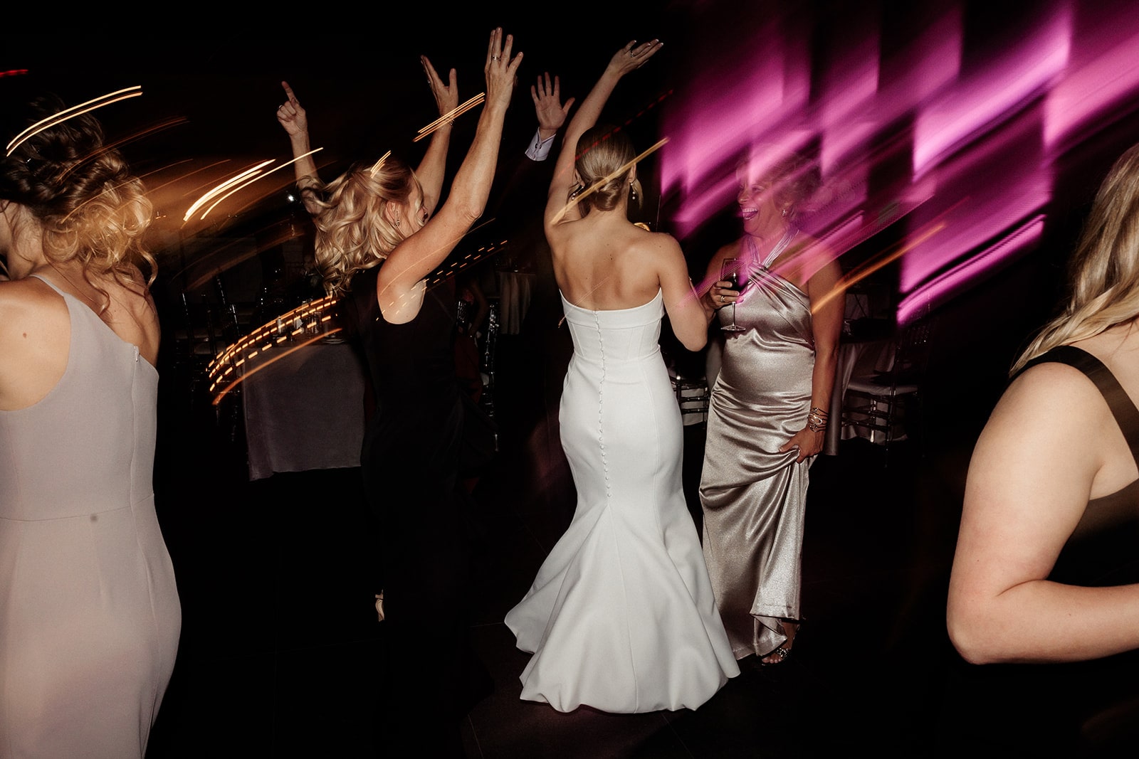 Bride dances with guests on the dance floor during her museum wedding reception